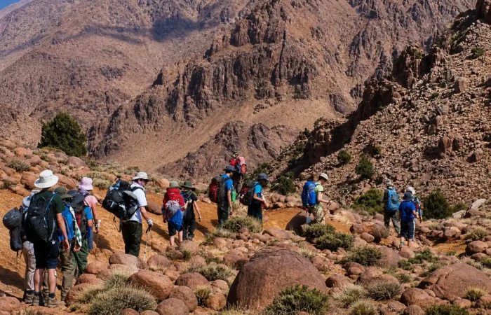 Group of hikers trekking in M Goun Valley near Ait Bouguemez in the High Atlas Mountains Morocco